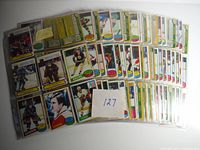 Top view of multiple hockey cards laid out in protective sleeves showing front player images from various NHL teams including Bruins and Flyers.