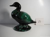 Front and side views of the ceramic duck figurine showing its form and color.