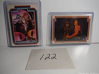 Front view of two KISS trading cards, #17 showing drummer Peter Criss and #41 showing Paul Stanley and Gene Simmons in stage costumes.