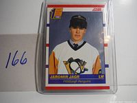 Front side of 1990 Score Jaromir Jagr rookie card showing player photo in Penguins uniform with Score branding and draft pick logo