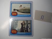 Two vintage Star Wars trading cards inside plastic sleeves. Card #25 shows Luke on landspeeder, card #46 featuring Luke with lightsaber with crease.