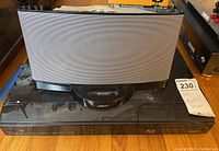 Bose SoundDock Series II speaker system placed on top of Sharp Blu-ray player showing front and overall condition.