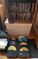 Box with multiple rows of CDs showing a variety of artists and titles from the 80s and 90s