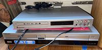 CyberHome DVR 1600 DVD recorder stacked on top of Sony RDR-VX530 VCR/DVD recorder, showing front panels with input ports and disc slots.