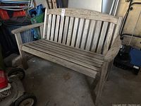 Front view of weathered wooden bench showing slatted seat and back