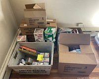 Boxes containing various light bulbs and fluorescent lamps, showing lot assortment.