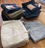 Stack of folded pants showing denim and slacks in multiple colors