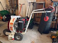 Full view of walk-behind power blower on wheeled metal frame