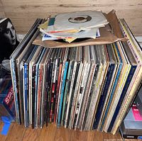 Front view of stacked vinyl records with loose sleeves on top