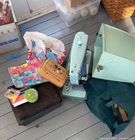 Photo showing the Singer sewing machine with some of the accessories and cases around it.