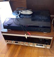 Front view showing Sony turntable stacked atop Sansui amplifier