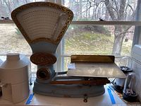 Overall view of light blue cast iron scale with brass details and metal platform