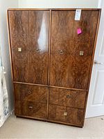 Front view showing burl wood grain finish, four cabinet doors with mixed replaced metal handles and six drawers with brass and metal handles.