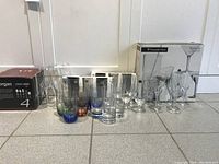 Photo of all glasses arranged on the floor showing variety including colored base glasses and clear glasses