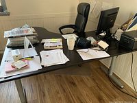 Black IKEA Bekant corner desk with right configuration and add-ons, including ergonomic office chair and dual monitors.