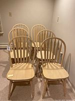 Six light wood dining chairs arranged in two rows, showing full set and overall shape.