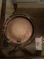 Top view of tarnished silverplated Oneida serving tray showing detailed engraving and pierced border.