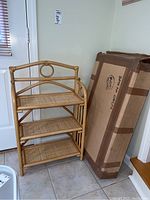 Two folding rattan book shelves placed next to each other, showing the overall size and one still in original packaging.