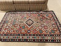 Top-down view showing entire geometric patterned rug with faded section near top side.