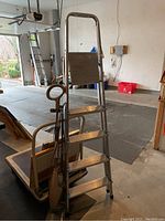 Side view of aluminum Baldray step ladder in garage with handle and steps visible