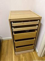 Front and right-side view of laminated storage dresser showing five drawers with top three drawers lighter wood finish and bottom two drawers darker wood finish.