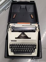 Adler portable typewriter inside open carrying case showing keyboard and platen roller.