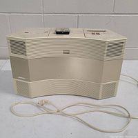 Front view of the Bose Acoustic Wave music system showing speaker grille and power cord.