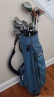 Full view of blue golf bag filled with multiple golf clubs