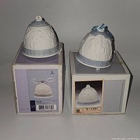 Two Lladro porcelain bells on top of original boxes showing front and year markings