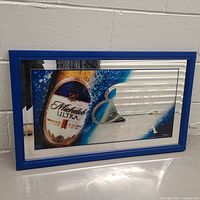 Framed Michelob Ultra beer bar mirror showing the front with bottle image and water splash on mirror surface.