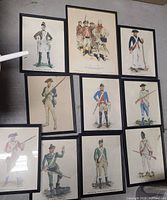 View showing all 10 framed soldier art prints arranged together on floor.