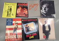 Seven vintage tour programs featuring Bruce Springsteen, Billy Joel, John Cougar Mellencamp, and others.
