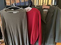 Four garments hanging on a rack: Holt Renfrew sweater and skirt set in olive green, red cashmere Scottish sweater, Gerry Weber blazer in dark olive/charcoal color.