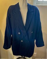 Front view of the dark navy Max Mara wool coat showing double-breasted buttons and wing sleeves on a mannequin.