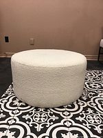 Front perspective of the round ottoman on patterned tile floor