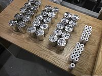 Table with three groups of thermal receipt rolls: 30 large silver foil wrapped rolls, 11 medium white rolls, and several small white rolls.