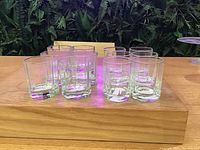 Front view of two groups of clear crystal glasses on a wooden table.