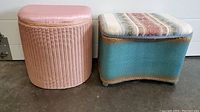 Two Lloyd Loom laundry hampers side by side on floor, pink round one and blue rectangular one
