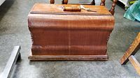 Wooden case front view with handle and key on top.