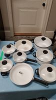 Full set of eight Ceradur Schott-Zwiesel pots and pans with lids, showing different sizes and handle types.
