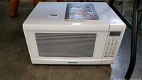 White Panasonic microwave model NN-SN668W showing front view with control panel and mesh window on door.