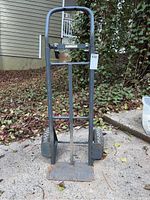Front upright view of Gleason Milwaukee hand truck showing upright frame, handle, and lift plate with surface rust.