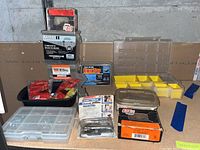 Photo of the assorted fasteners, screws, nails, drywall repair clips, and plastic staples on a shelf with packaging labels visible.