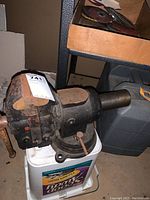 Side and top angle view of large cast iron bench vice showing rust and paint wear.