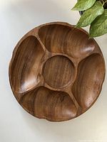 Top view of round wooden party snack tray with five compartments, showing natural wood grain and smooth finish.