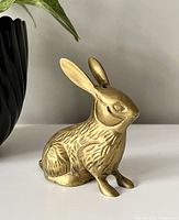 Front-right angle view of the brass bunny showing texture details and patina.
