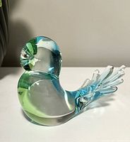Side view of the vintage Chalet glass bird figurine showing green and blue colors and clear glass tail detail