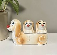 Photo of the assembled dachshund salt and pepper shaker set showing the long dog body with two dog head shakers inserted.