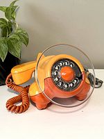 Front-angle view of full orange airplane phone with handset in place