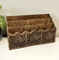 Side angled view showing carved floral design and compartment structure